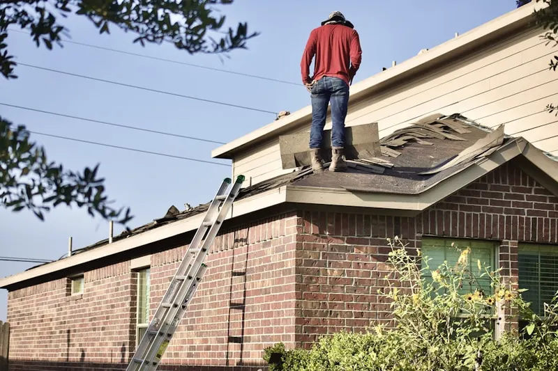 Professional roofer working on a residential roof in Topsham
